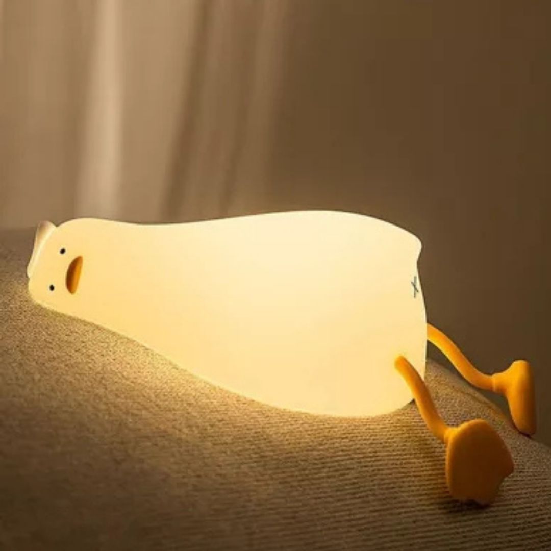 Oplaadbaar nachtlampje in de vorm van een liggende eend (Lie In Peace Duck) van gifvrij siliconen, perfect voor een veilige kinderkamer.